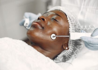 A woman receiving a microcurrent facial treatment, related to safety of such procedures.