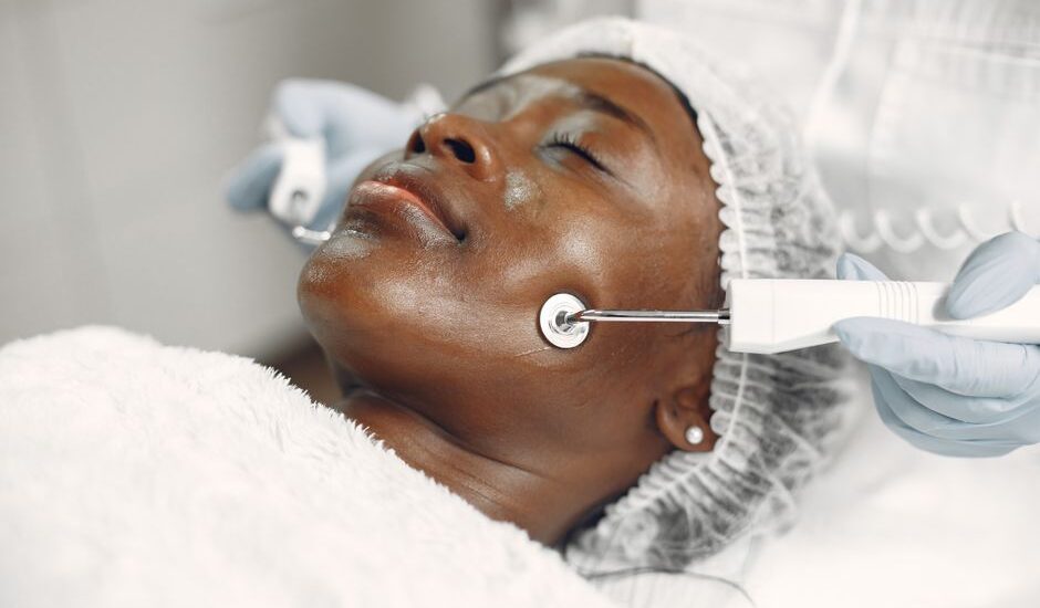 A woman receiving a microcurrent facial treatment, related to safety of such procedures.