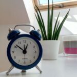 A blue alarm clock sits on a table, highlighting features of blue light alarm clocks.