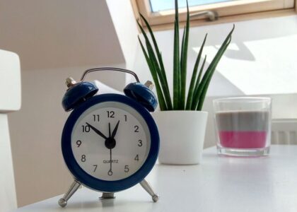 A blue alarm clock sits on a table, highlighting features of blue light alarm clocks.