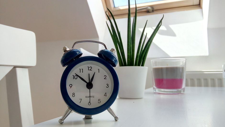 A blue alarm clock sits on a table, highlighting features of blue light alarm clocks.
