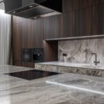 A sleek kitchen countertop featuring an electric pill crusher among modern appliances.