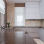 A sleek kitchen featuring a dark countertop and minimalist cabinetry, relevant to UV cleaning water bottles.