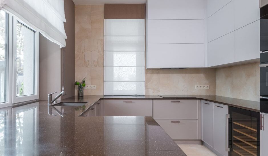 A sleek kitchen featuring a dark countertop and minimalist cabinetry, relevant to UV cleaning water bottles.