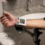 A person checks their blood pressure with a monitor on their wrist, relevant to blood pressure monitors reviews.