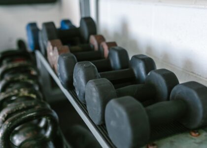 A rack displaying various dumbbells, illustrating the difference between dumbbells and kettlebells.