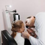 A doctor examines a child's ear, relating to hearing aids and cochlear implants.