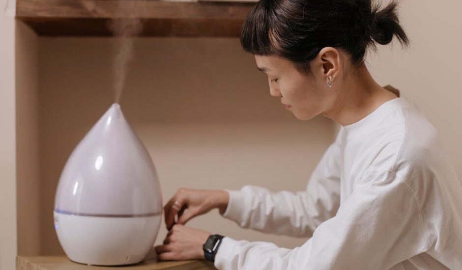 A person adjusting a humidifier, illustrating the function of humidifiers in contrast to dehumidifiers.