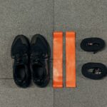 Image showing resistance bands and tubes alongside athletic shoes, illustrating the differences between them.