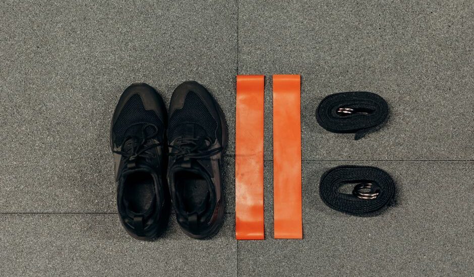 Image showing resistance bands and tubes alongside athletic shoes, illustrating the differences between them.