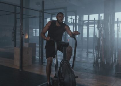 A man exercises on an air bike, illustrating the air bike's use in cardio workouts compared to elliptical bikes.