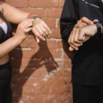 Two individuals adjusting fitness trackers on their wrists, relating to heart rate accuracy.