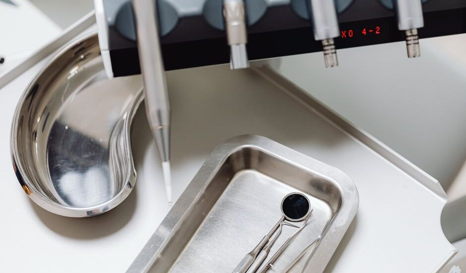 A dental mouth mirror and tools on a tray, illustrating cleaning methods.