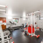 A home gym featuring a treadmill and various fitness equipment, relevant for replacing a treadmill belt.