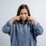 A woman demonstrating jaw exercises, relevant to using a jaw exerciser.