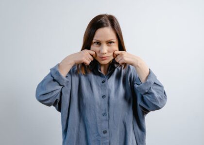 A woman demonstrating jaw exercises, relevant to using a jaw exerciser.