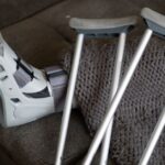 A knee scooter and crutches on a couch, illustrating mobility aids for recovery.