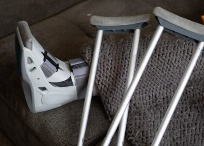 A knee scooter and crutches on a couch, illustrating mobility aids for recovery.