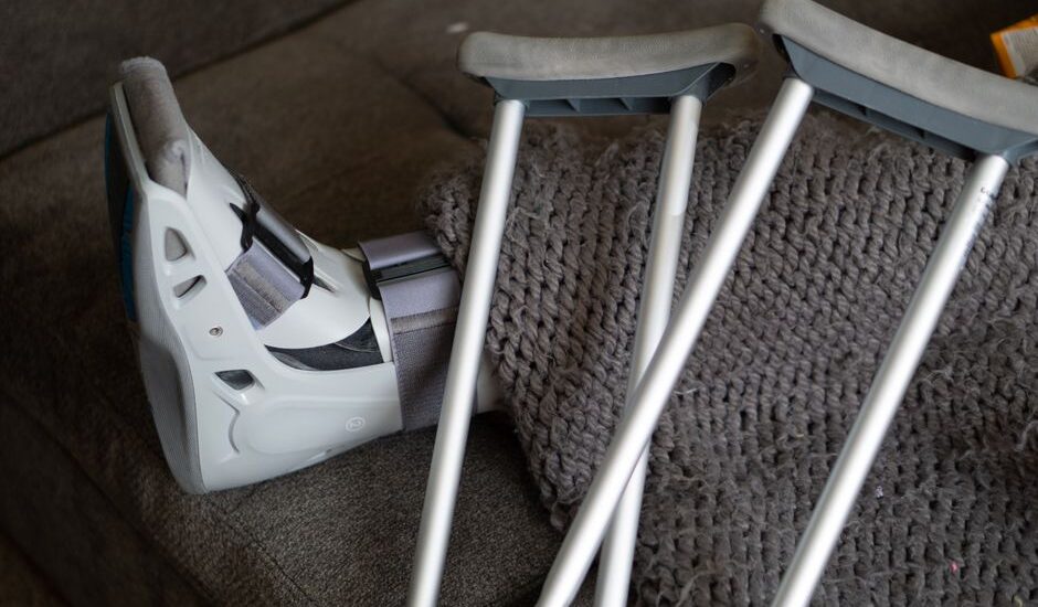 A knee scooter and crutches on a couch, illustrating mobility aids for recovery.