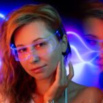 A woman wearing light therapy glasses designed to improve sleep, with colorful lights in the background.