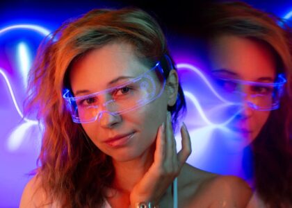 A woman wearing light therapy glasses designed to improve sleep, with colorful lights in the background.