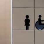 Bathroom signage indicating facilities for women and wheelchair users, relevant for adjustable shower chair discussions.