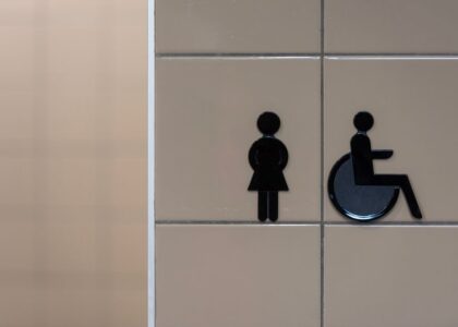 Bathroom signage indicating facilities for women and wheelchair users, relevant for adjustable shower chair discussions.