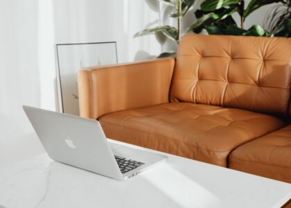 A workspace featuring a laptop on a marble table, highlighting the importance of adjustable footrests for comfort.