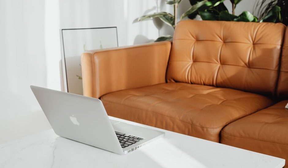 A workspace featuring a laptop on a marble table, highlighting the importance of adjustable footrests for comfort.