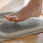 A foot stepping on a textured circulation booster, related to foot health.