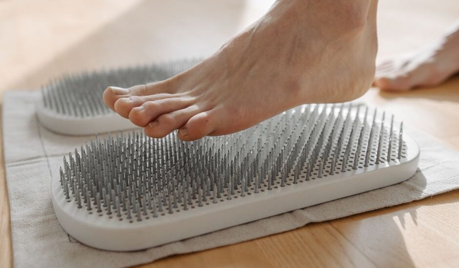 A foot stepping on a textured circulation booster, related to foot health.