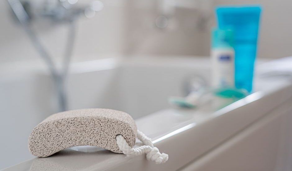 A pumice stone rests on the edge of a bathtub, relating to callus treatment.