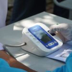 A person calibrating a digital blood pressure cuff on a table, relevant to blood pressure measurement.