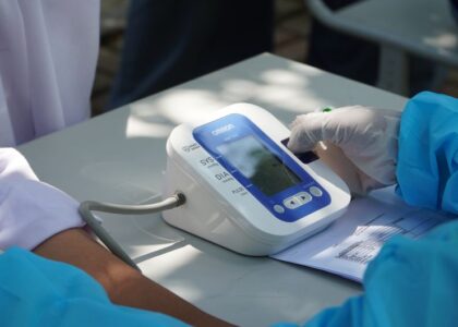 A person calibrating a digital blood pressure cuff on a table, relevant to blood pressure measurement.