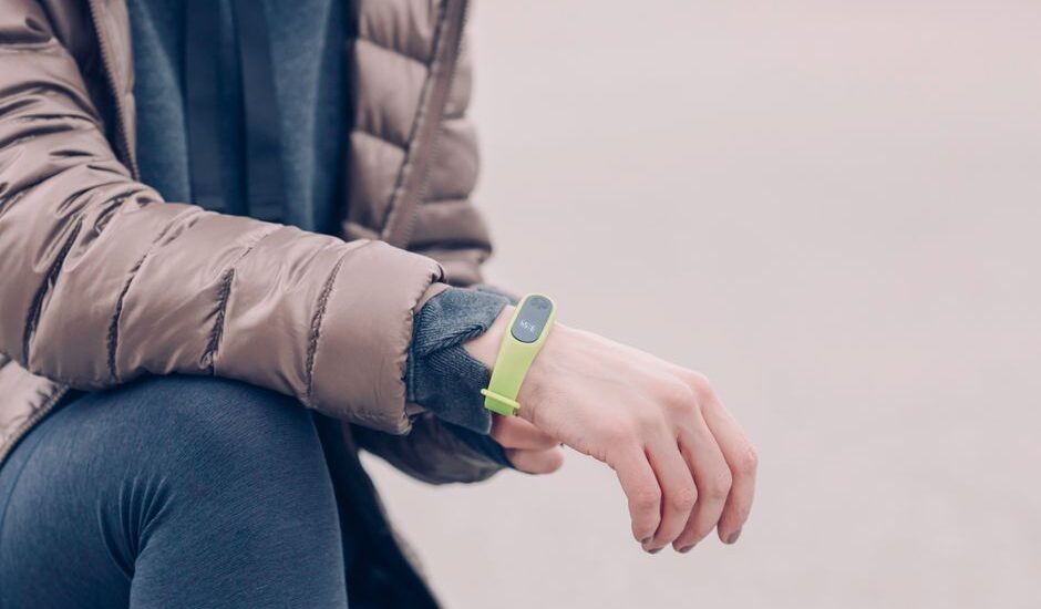 A person wearing a fitness tracker on their wrist, illustrating how to change the band.