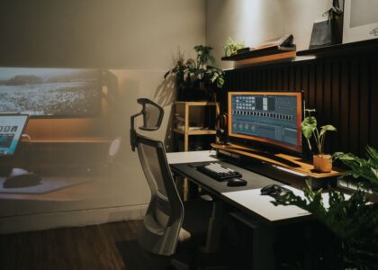 A modern home office featuring an ergonomic chair and a large monitor, relevant for orthopedic seat cushions.