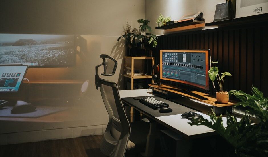 A modern home office featuring an ergonomic chair and a large monitor, relevant for orthopedic seat cushions.