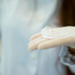 A hand wearing a glove holds a sleep apnea mouthpiece, relevant to sleep apnea solutions.